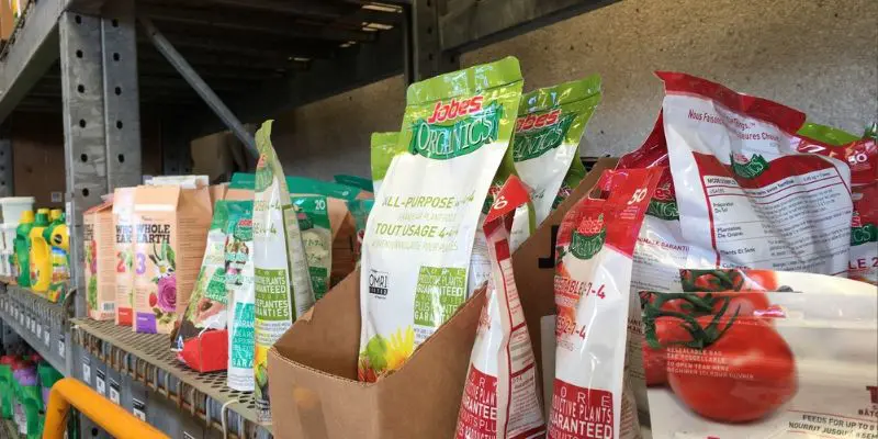 Commercial garden fertilizers on a shelf at a garden center. |Over-fertilizing fruit trees.